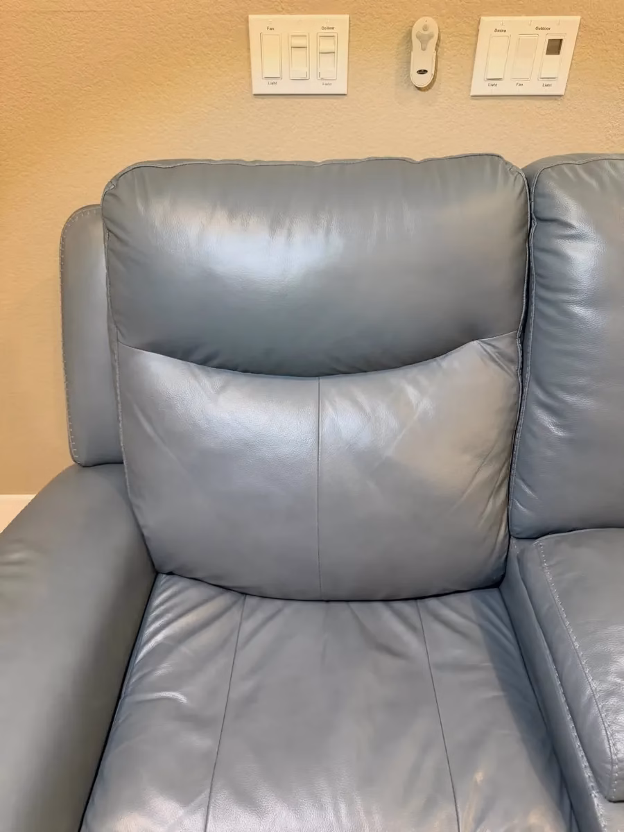 Blue leather recliner headrest after repair and recoloring by Leather Repair Lab